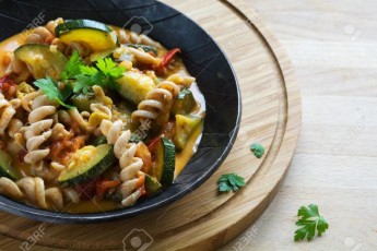 wholewheat pasta with zucchini vegetables in a black frying pan